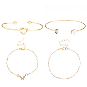 Macro-opname van 4-delige gouden armbandset met parels, kristal en knoopontwerp