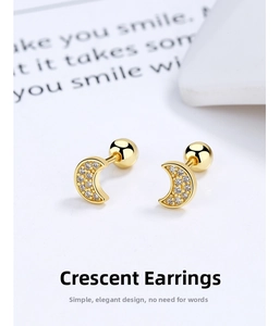 Close-up of gold crescent moon earrings with cubic zirconia and screw ball backings