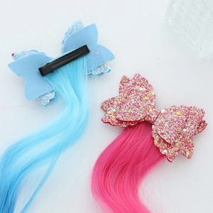 Close-up of glitter bow hair clips with long colorful gradient synthetic hair extensions