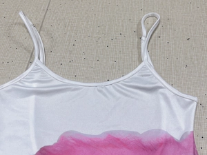 Détail des bretelles réglables et du décolleté en U d'une robe en satin rose