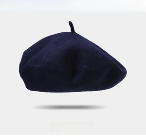 Detail of navy blue wool beret featuring exquisite red heart embroidery and fine fabric texture