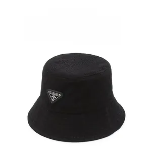 Detail showing the wavy textured fabric and fashion triangle plaque on the black bucket hat