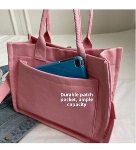 Dettaglio borsa tote in tela rosa con tasca frontale e grande capacità di contenimento