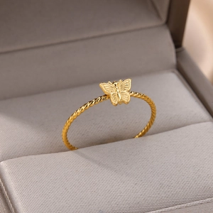Detailed macro shot of a gold butterfly ring with a textured twist band in a jewelry box