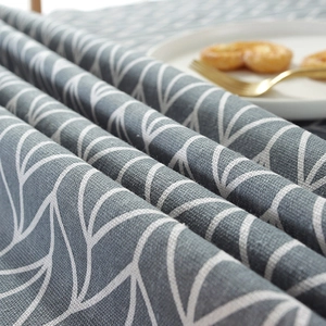 Close-up of gray cotton linen tablecloth featuring white geometric leaf patterns and texture