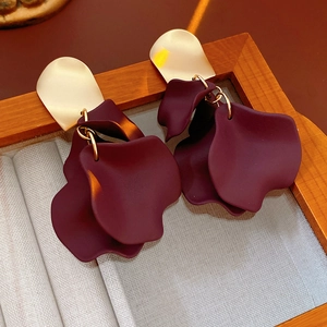 Macro shot of dark purple petal flower earrings with polished gold metallic stud detail