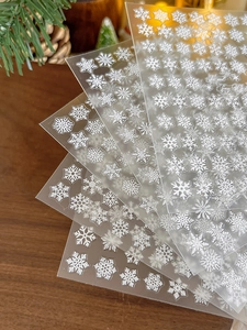 Detailed view of 3D embossed white snowflake nail stickers with Christmas festive decor