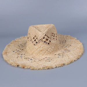 Detail of raffia sun hat featuring hollow diamond weave patterns and frayed edges
