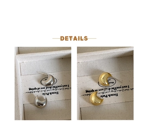 Detailed view of C-shaped crescent stud earrings in polished gold and silver finishes