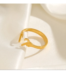 Detailed shot of golden hand gesture heart ring on elegant white silk fabric
