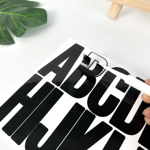 Detail showing peeling a 3-inch black vinyl alphabet letter sticker for DIY decor