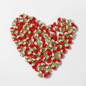 Red and white strawberry alloy pendants arranged in a heart shape on white background
