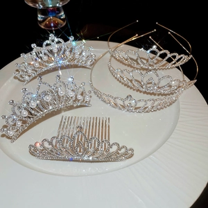 Vue détaillée de couronnes de mariée argentées avec strass brillants et perles sur plat blanc