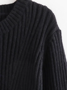 Detail of black knit dress showing fine ribbed texture and premium shoulder stitching