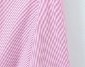 Close-up of pink and white vertical stripe fabric with soft cotton texture and drape