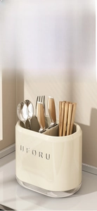 Detail of cream multi-compartment wall-mounted kitchen utensil holder for spoons and cutlery