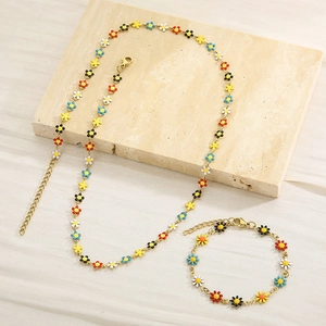 Golden titanium steel jewelry set featuring colorful daisy charms on necklace and bracelet