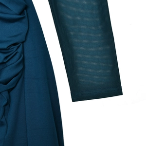 Detail of dark blue dress sleeve showing sheer mesh fabric and pleated ruffles