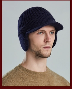 Profile view of men's thermal knit hat with ear flaps and visor in dark blue