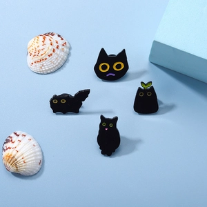 Set of four cute cartoon black cat enamel pins with yellow eyes on a light blue background