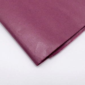 Primer plano de papel seda fucsia doblado mostrando textura suave y gran detalle