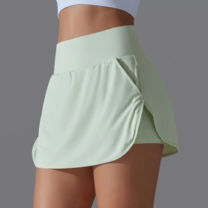 Detail view of high-waist light green tennis skort with side pocket and curved hem