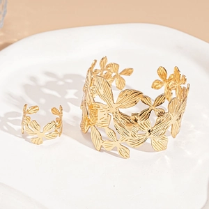 Detail of gold hollow flower ring and bracelet set with delicate plant vein textures