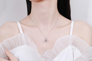 Close-up of a heartbeat heart pendant necklace with a dancing moissanite stone