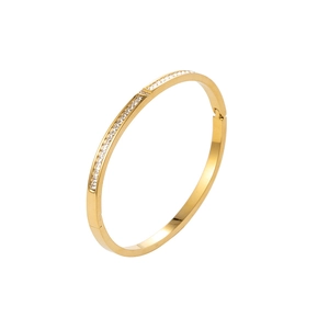 Elegante bracciale rigido dorato con zirconi quadrati e chiusura a cerniera su bianco
