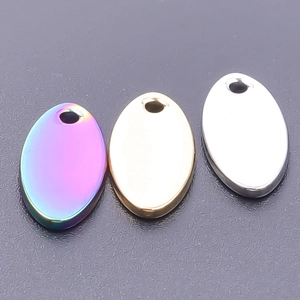Detail of oval stainless steel pendants in iridescent gold and silver finishes