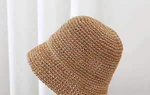 Detailed macro view of khaki woven straw texture and artisan sun hat craftsmanship