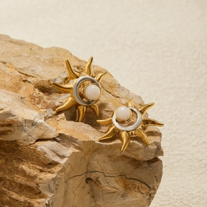 Detailed view of sun and moon two-tone titanium steel earrings with white pearl inlay