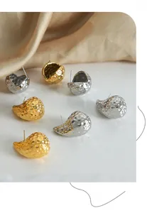 Detailed view of irregular water drop earrings with hammered texture in gold and silver