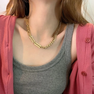 Detailed close-up of golden titanium steel Cuban chain necklace worn by a model