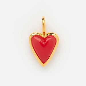 Detail shot of heart-shaped gold-plated charm with vibrant red enamel inlay on white back