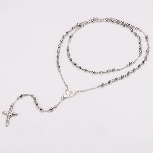 Detailed macro view of silver rosary necklace with Mary heart link and crucifix pendant
