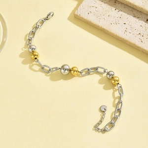Detail of interlocking gold and silver steel beads on textured chain with lobster clasp