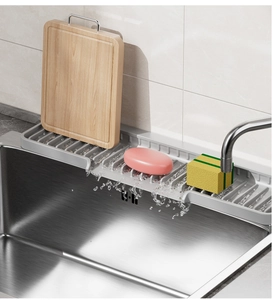 Gray silicone kitchen sink splash guard with sloped drainage for faucets and sponges