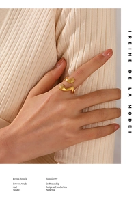 Detail of gold-plated stainless steel hugging hands ring worn on a finger