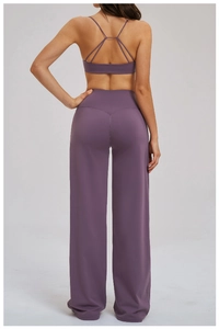 Rear view of deep purple yoga set with V-cut high waist wide leg pants and cross straps