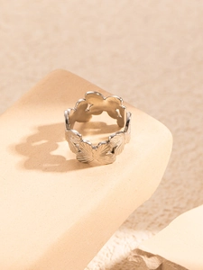 Detailed macro view of silver hollow butterfly pattern on titanium steel ring band