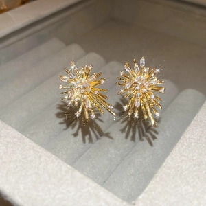 Macro shot of gold firework stud earrings with zircon crystals on a velvet display