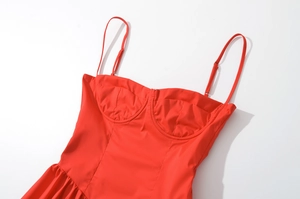 Détail d'une robe rouge ajustée avec bretelles fines réglables et coutures précises