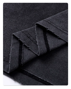 Macro shot of dark grey washed cotton fabric with raw edge hem and detailed texture