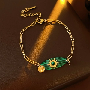 Détail du bracelet vintage doré avec pierre de malachite verte et charme soleil