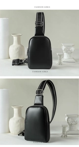 Detail of black soft leather crossbody bag with dual zippers and striped webbing strap