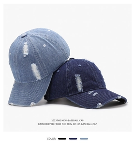 Close-up of distressed denim baseball caps with ripped details in blue and light blue