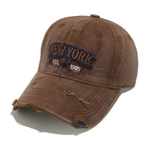Detailed close-up of brown vintage wash baseball cap with New York 3D embroidery