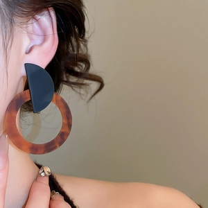 Close-up of model wearing retro resin hoop earrings with tortoiseshell texture