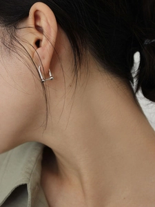 Gros plan d'un modèle portant des boucles d'oreilles fer à cheval en argent 925 massif